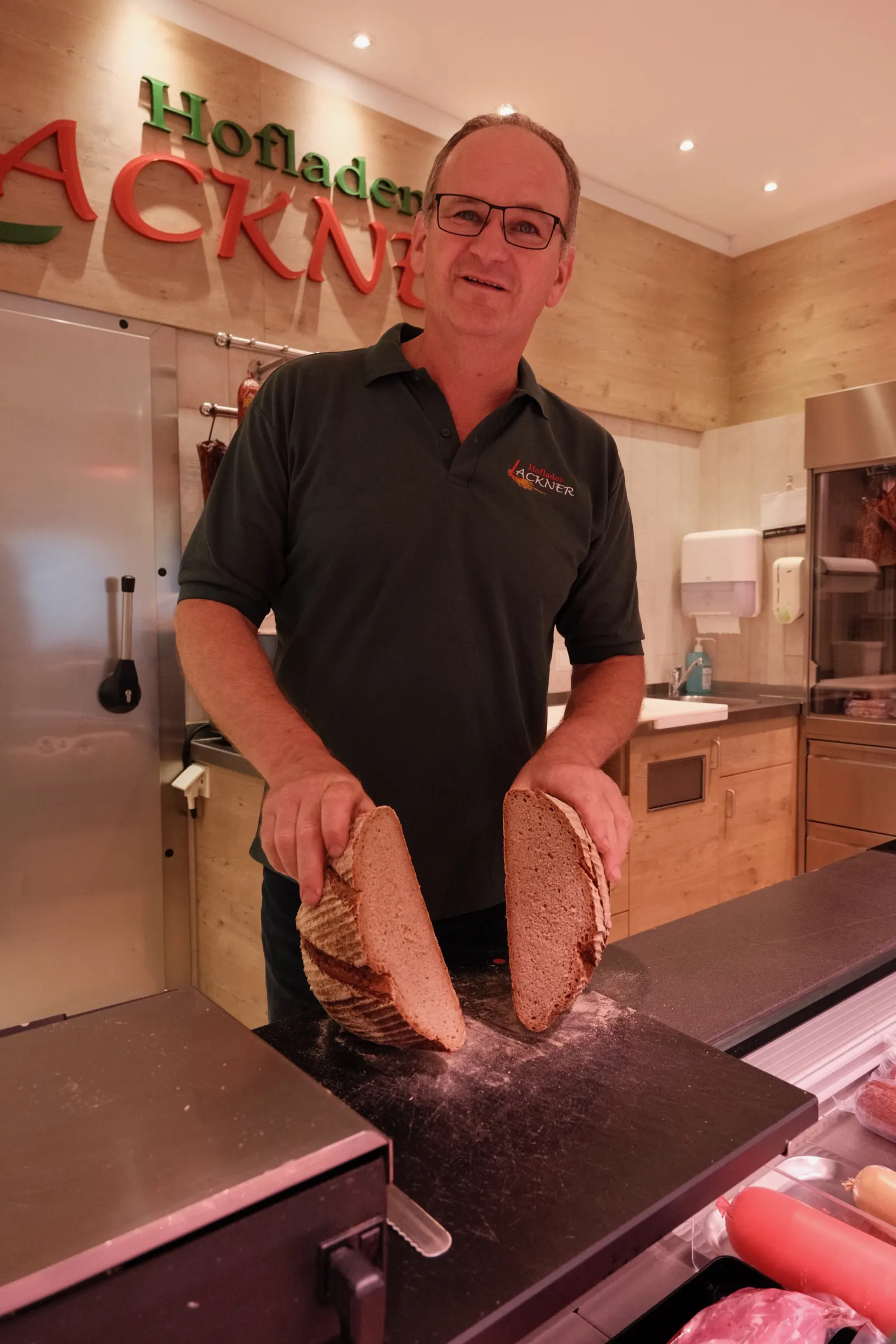 Heinrich schneidet Brot im Hofladen Lackner an